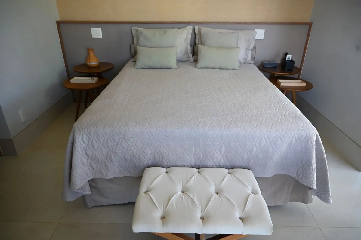 Cama de casal com cabeceira acolchoada e banco ao pé