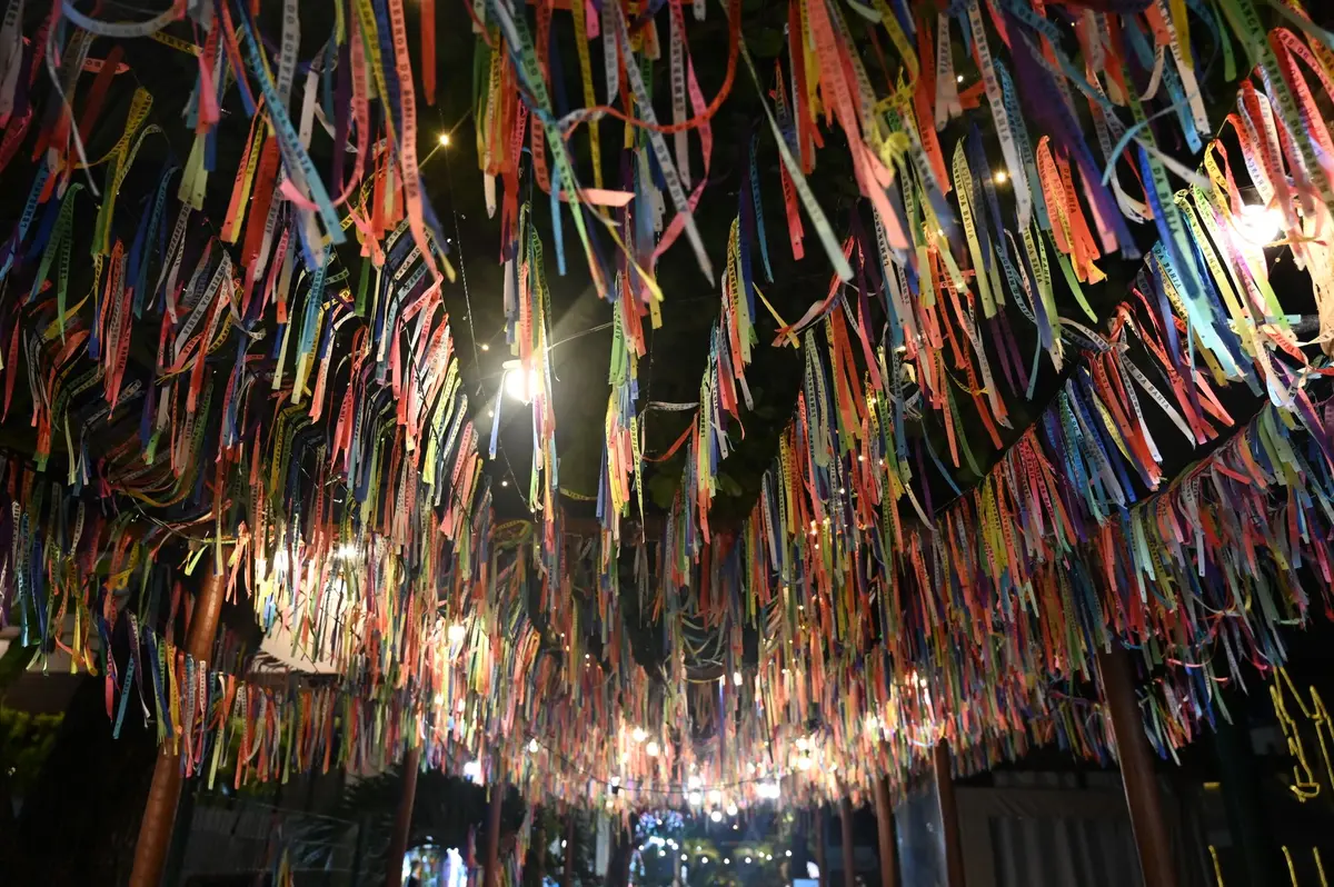 Fitas coloridas penduradas sob luzes na vila de Praia do Forte