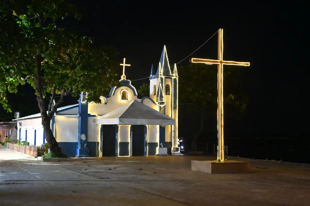 Igreja da vila de Praia do Forte à noite, com a cruz iluminada